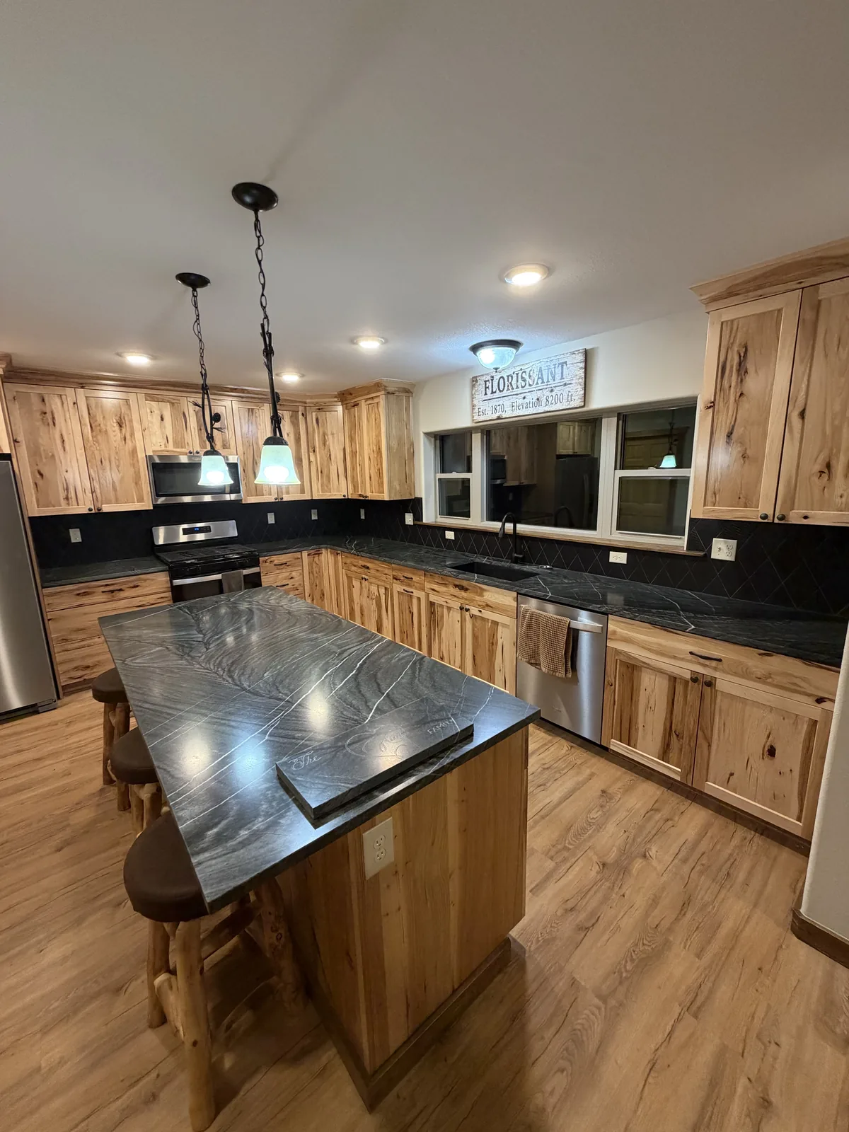 Kitchen with dark polished stone island and backsplash detail
