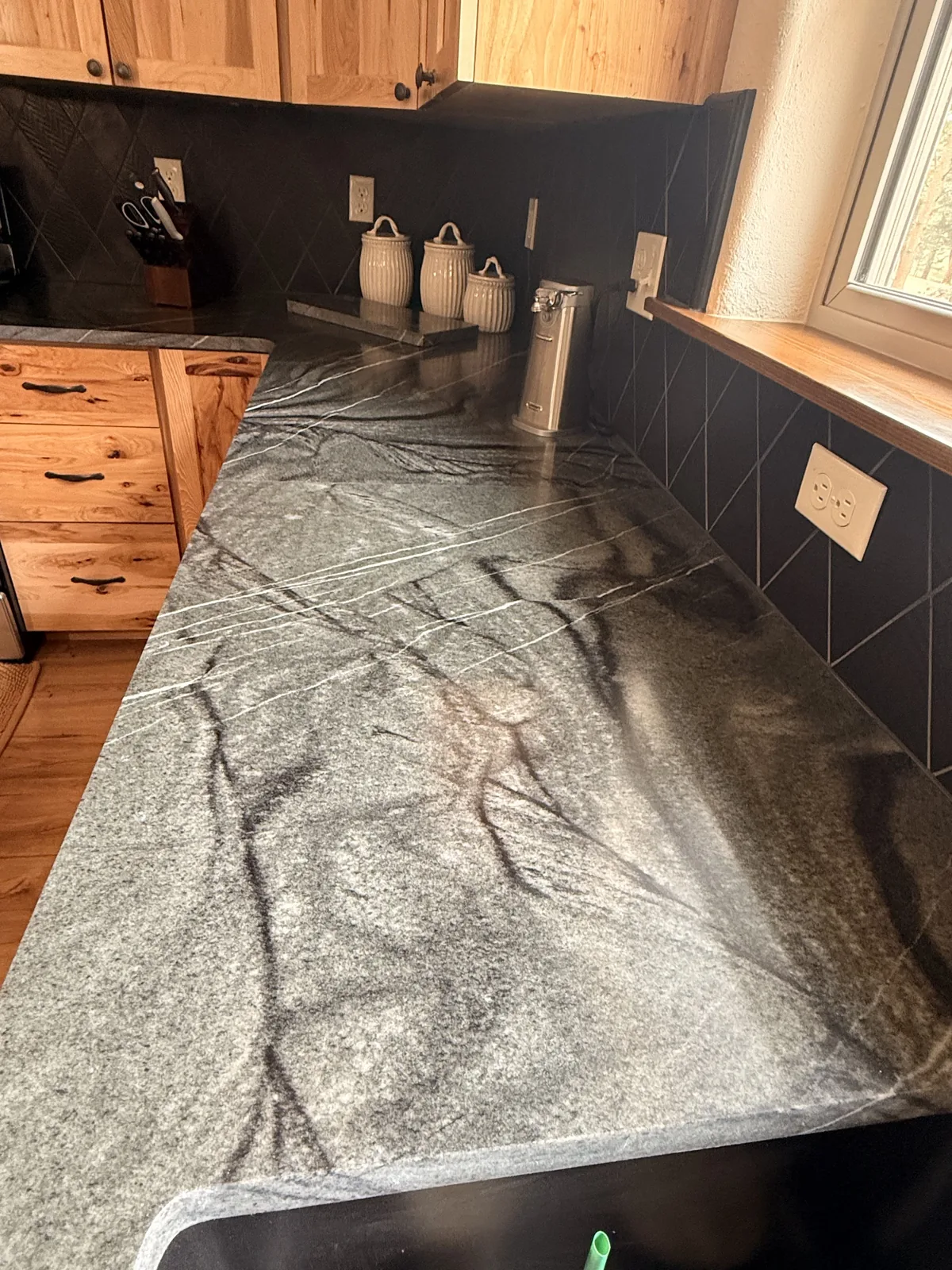 Gray stone countertop detail beside a kitchen window