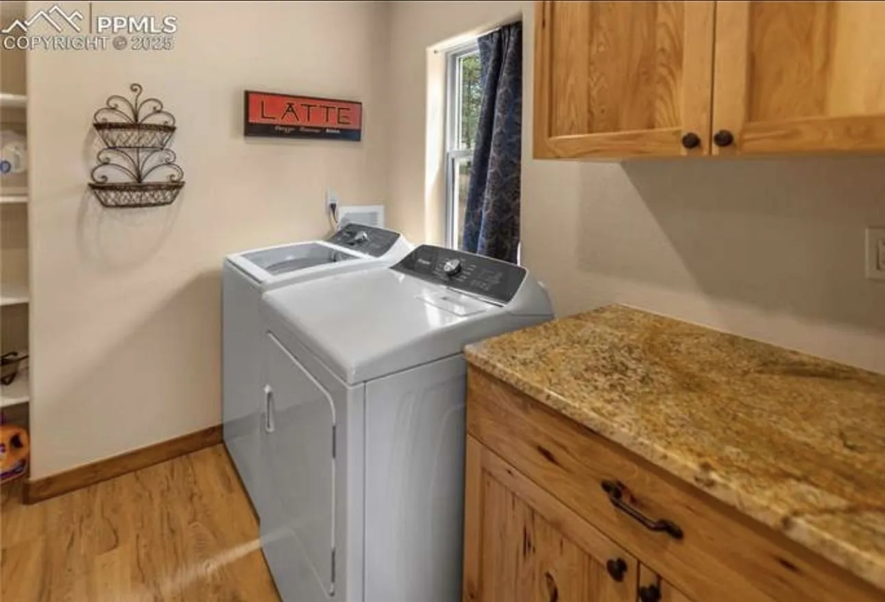 Laundry room counter with granite surface beside washer and dryer