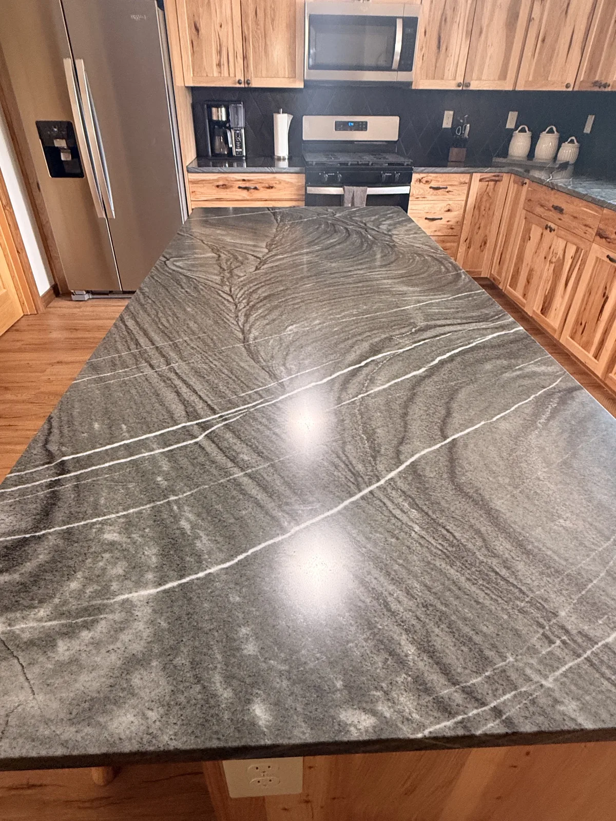 Polished gray stone island surface with reflective finish