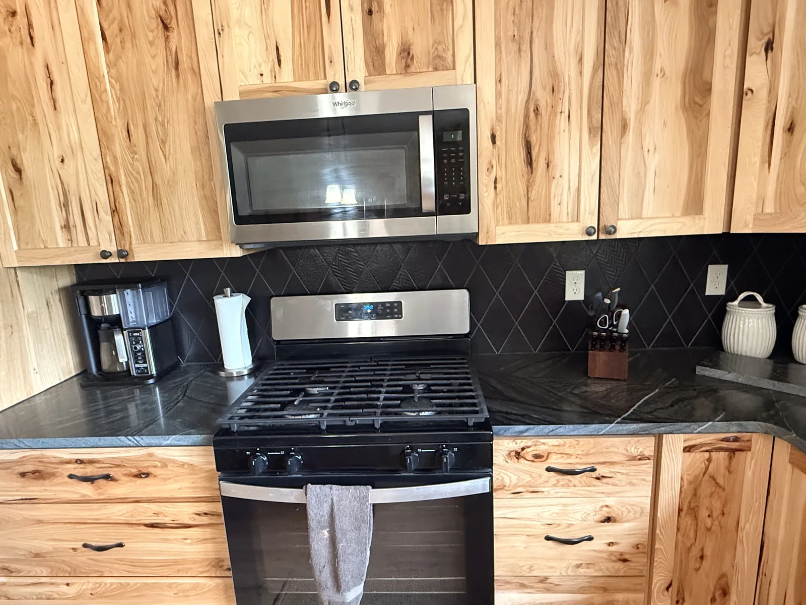 Kitchen range wall with black backsplash and stone counter finish