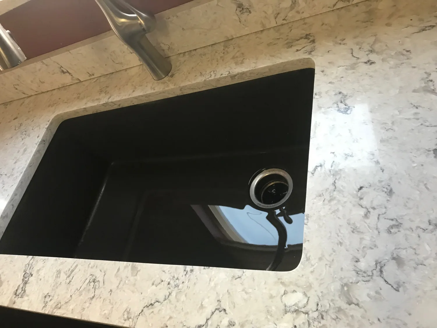 Dark sink set into a stone countertop