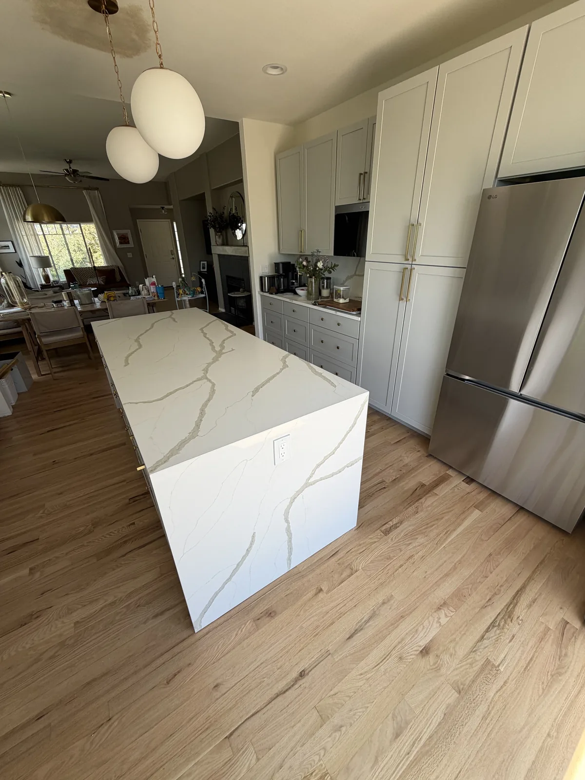 Finished double waterfall island with white counters and pendant lights