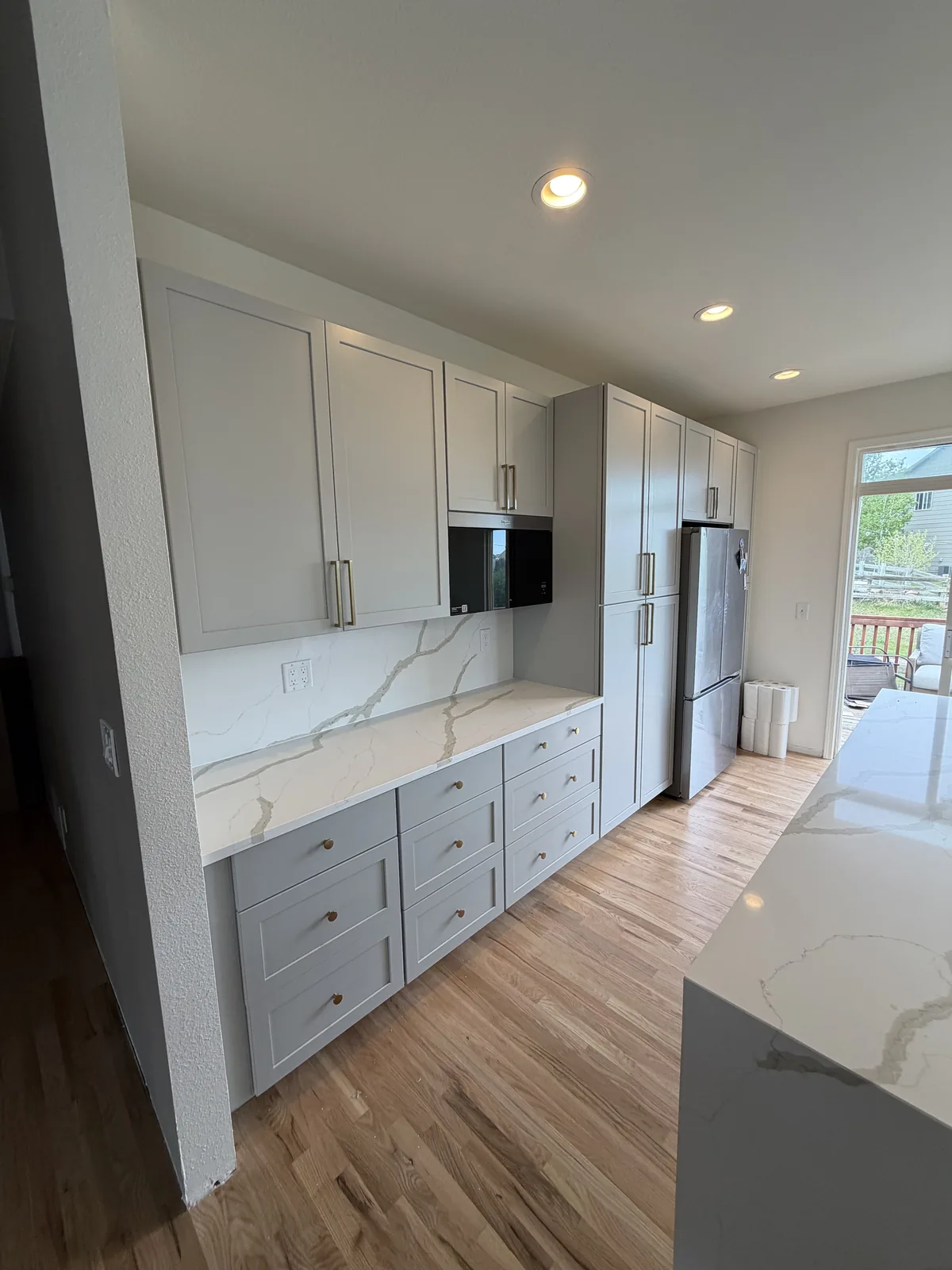 Finished cabinet wall and double waterfall island in kitchen remodel