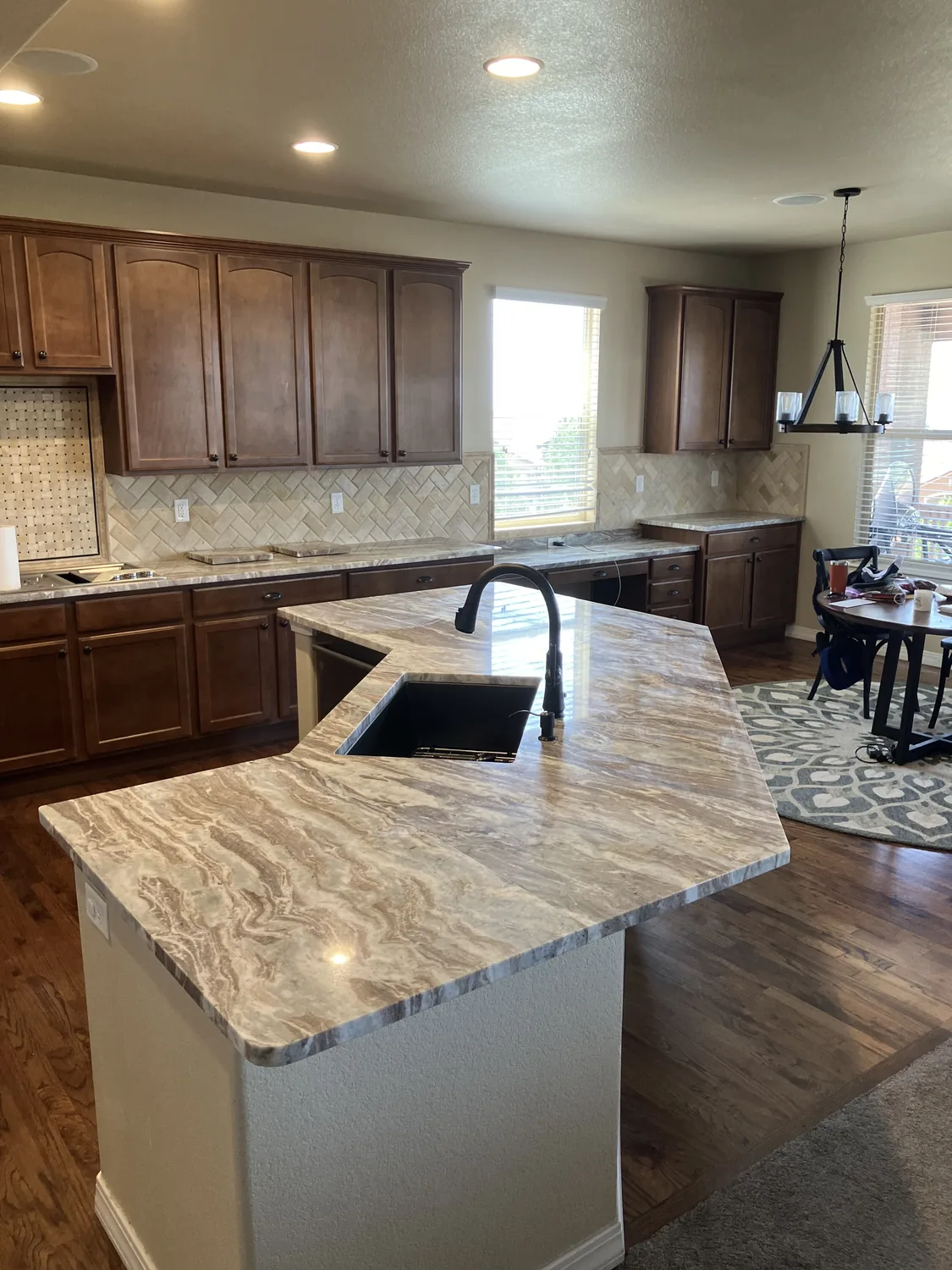 Finished kitchen island with stone countertop viewed from the side
