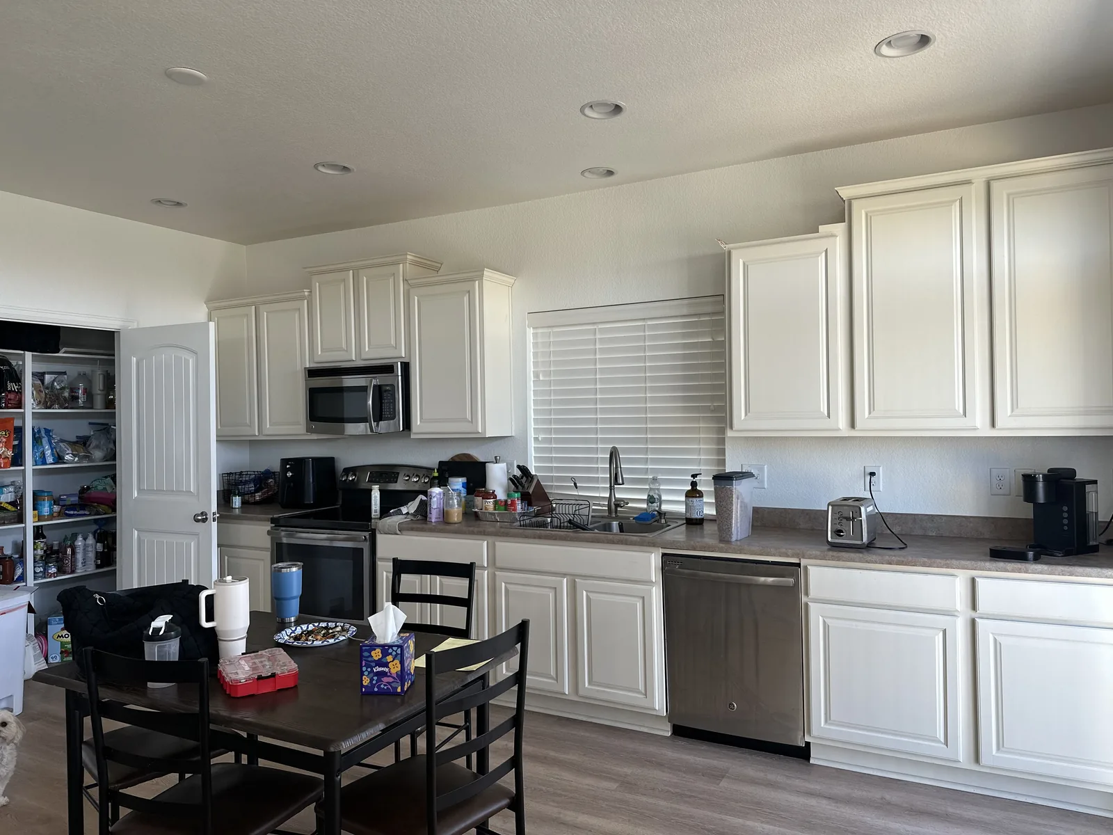 Kitchen before final remodel work with white cabinets and temporary table