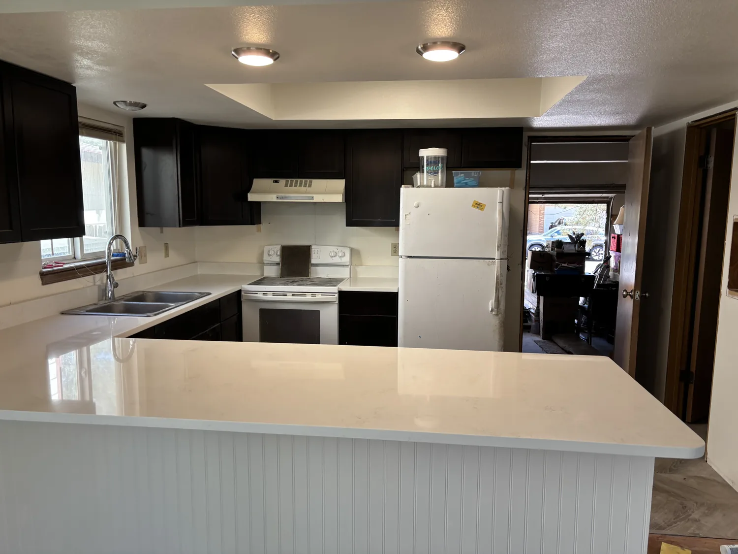 Finished kitchen remodel with a white island and dark cabinets