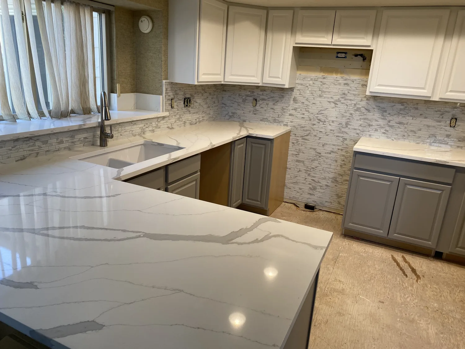 Wide finished kitchen with light stone counters