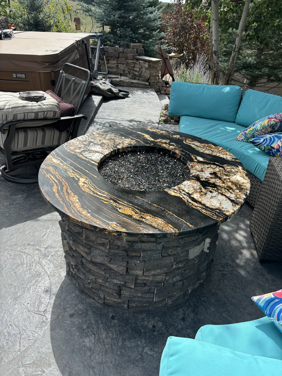 Outdoor custom stone fire table with seating around it
