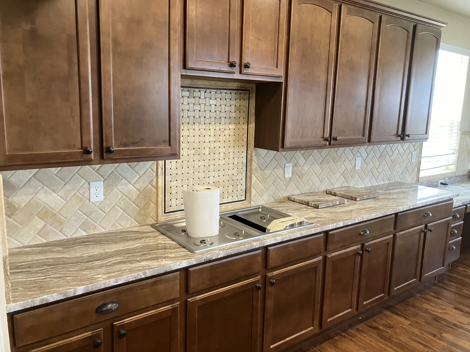 Wood cabinet kitchen with stone countertops and backsplash detail