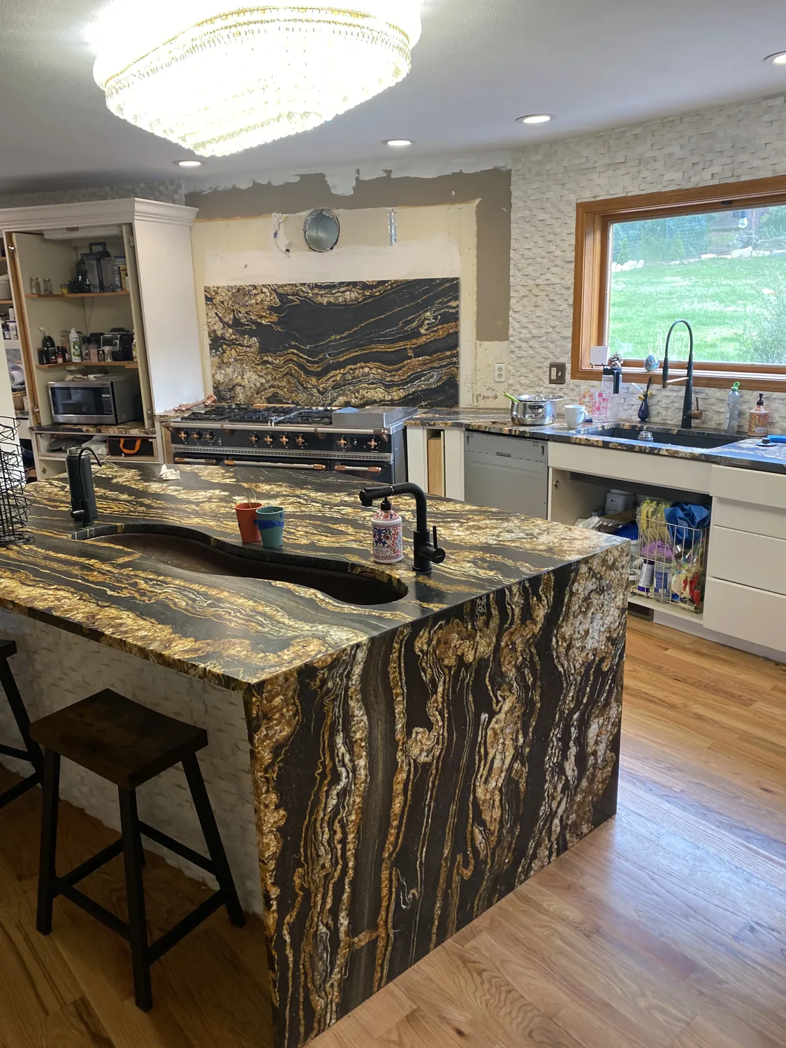 Stone island with seating and finished kitchen work surfaces