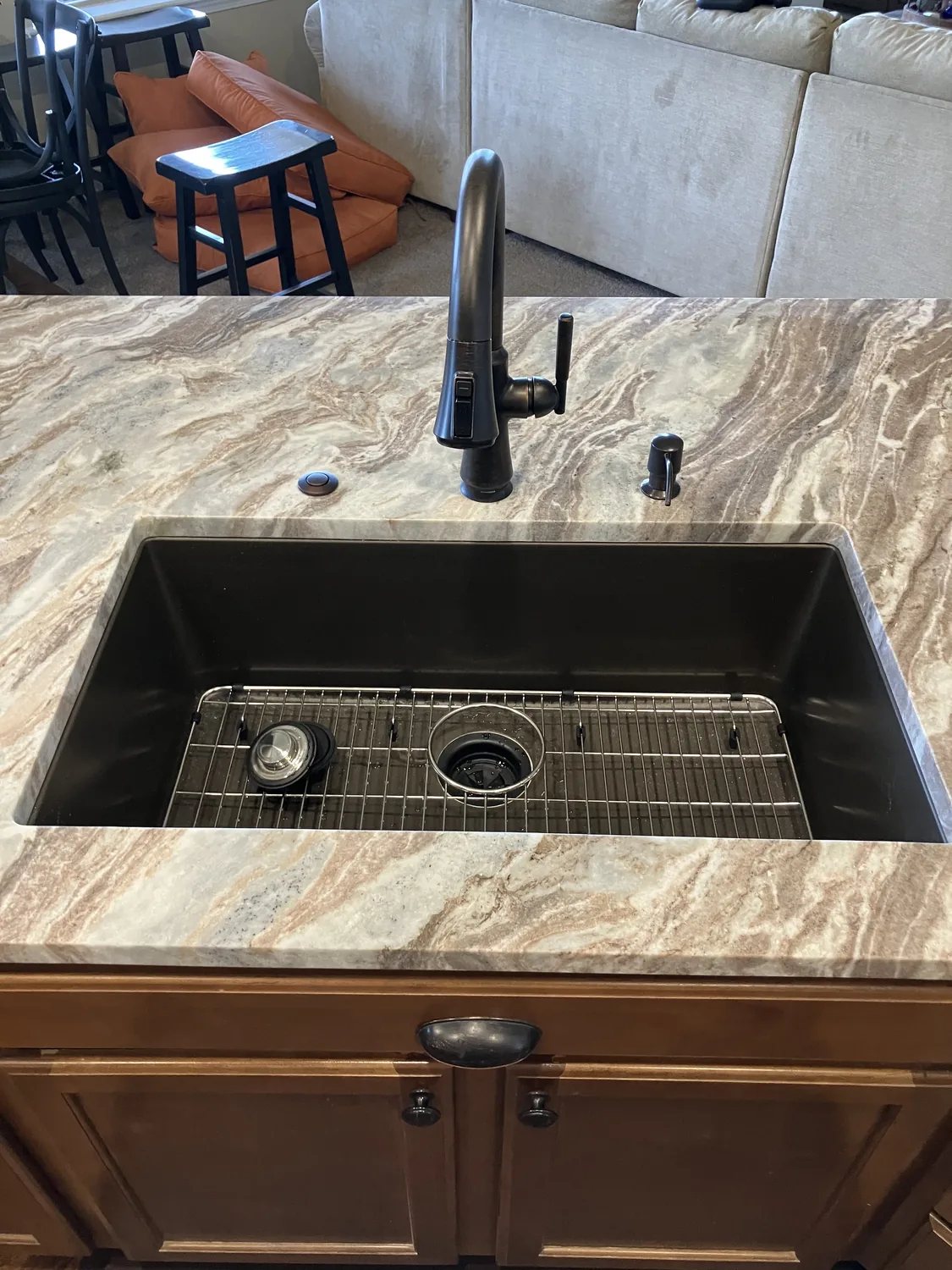 Stone countertop with sink cutout and dark sink hardware