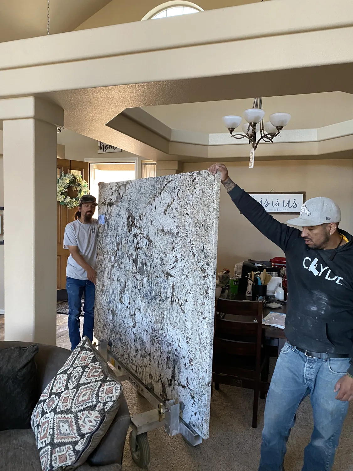 Stone slab being carried into a kitchen work area