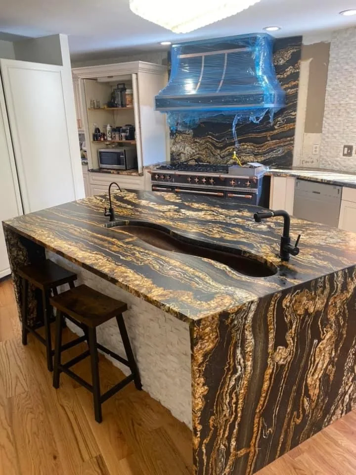 Finished kitchen with a dramatic waterfall stone island