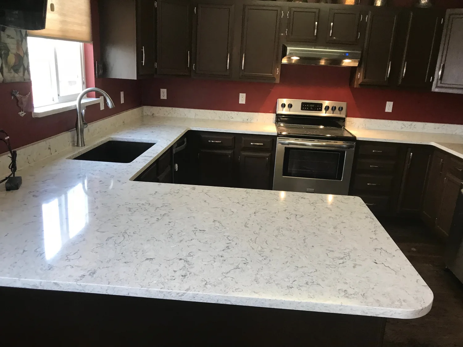White island set into a dark kitchen remodel